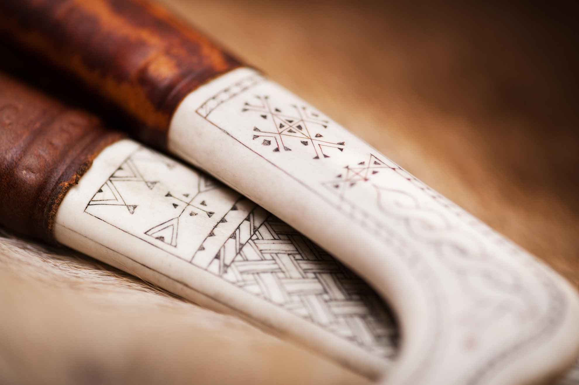 Close-up van twee traditionele Sami-messen. Handgemaakt met een handvat van rendierhoorn versierd met traditioneel Sami-houtsnijwerk.