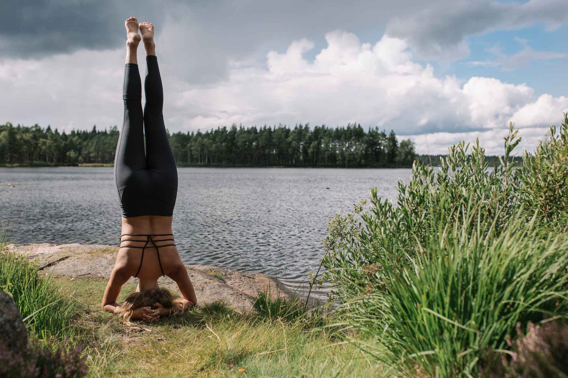 Een vrouw doet yoga bij een meer in Zweden.