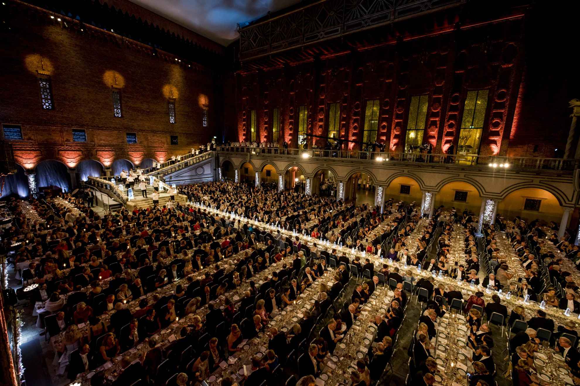 Een enorme zaal met meerdere tafels met gasten tijdens het Nobel banket.
