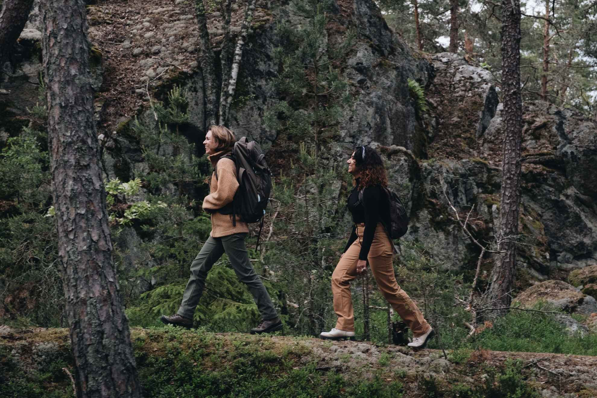 Twee vrouwen in buitenkleding wandelen in een bos.