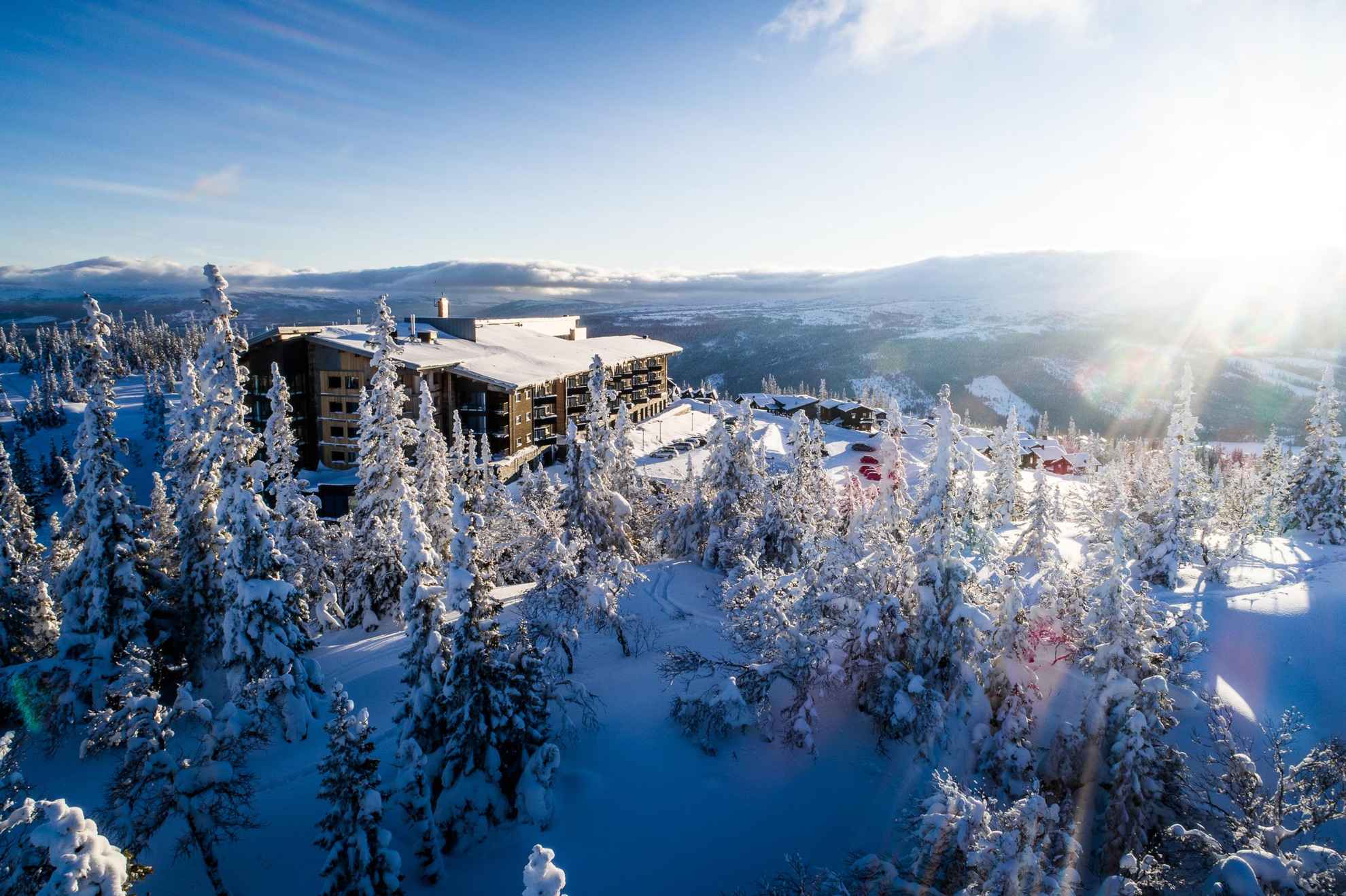 Winterse aanblik van een hotel gelegen op de top van de berg gezien in het zonlicht.