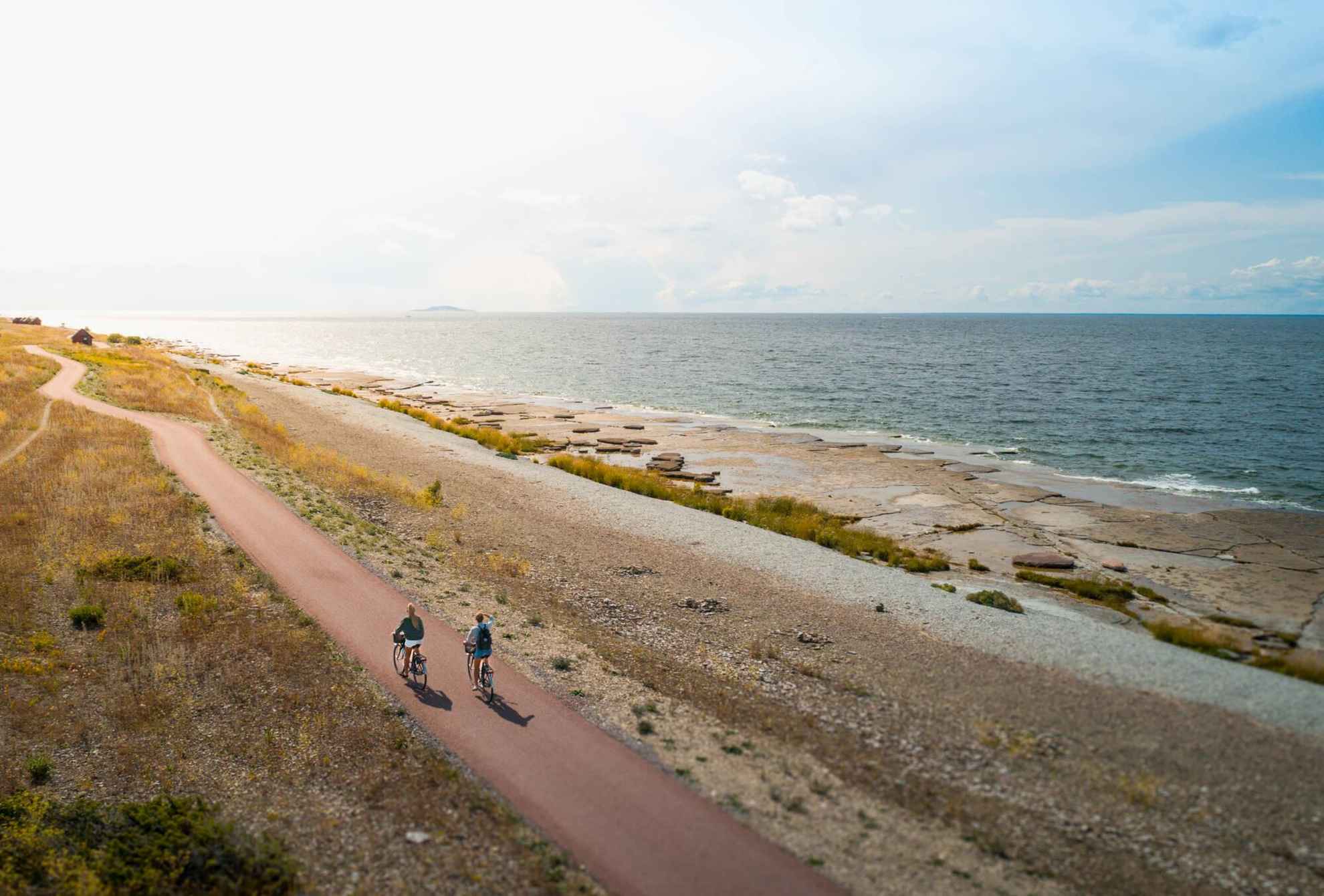 Twee vrouwen van bovenaf gezien, fietsend op een pad langs de zee op het eiland Öland.