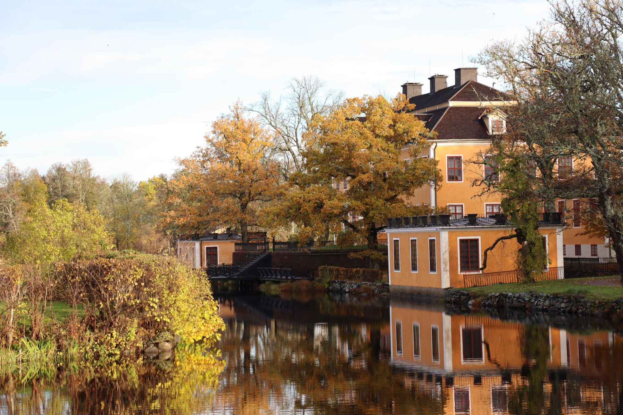 De huizen van Lövstabruk met oranje gevel en witte biesjes aan het water.