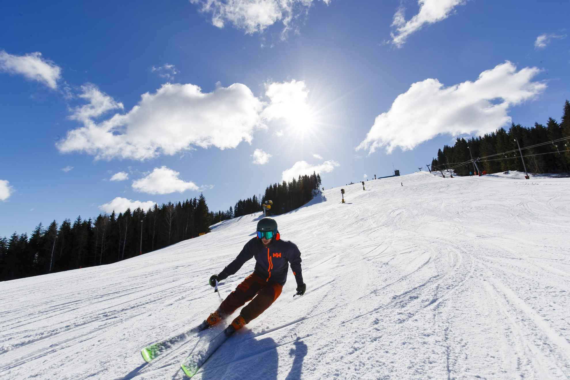 Een persoon is aan het alpineskiën op een zonnige winterdag.