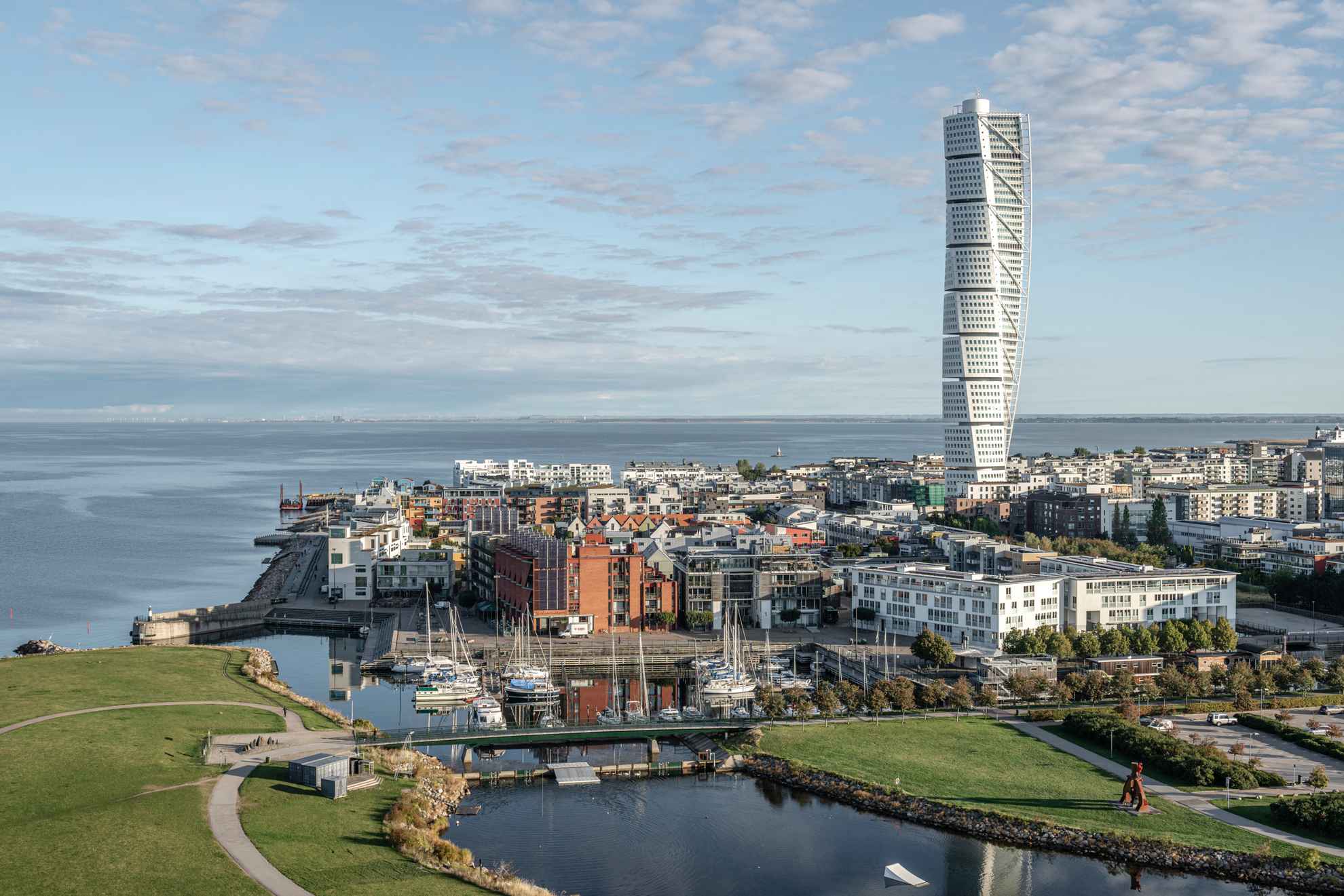 Luchtfoto van moderne gebouwen in een havengebied met een groot hoogbouwgebouw.