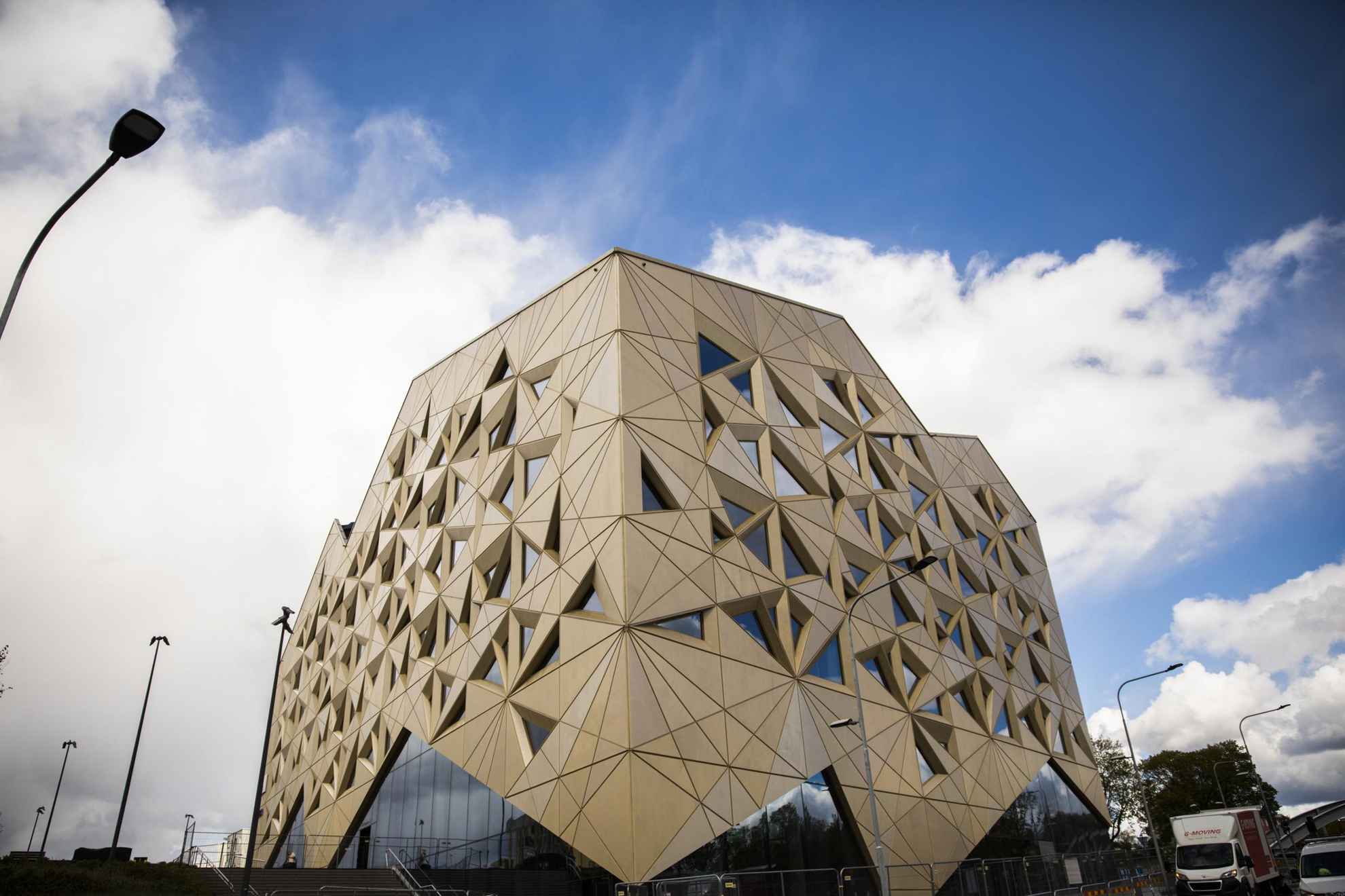 Een driehoekig kantoorgebouw met glinsterende edelstenen muren.