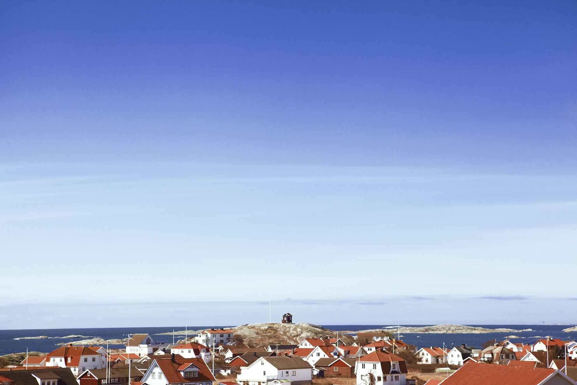 A view of white houses with red rooftops with the archipelago in the background.