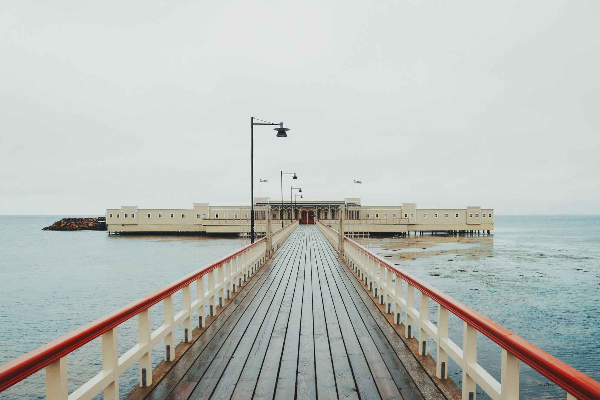 Een lange houten pier die leidt naar een koudwaterbadhuis in Malmö.