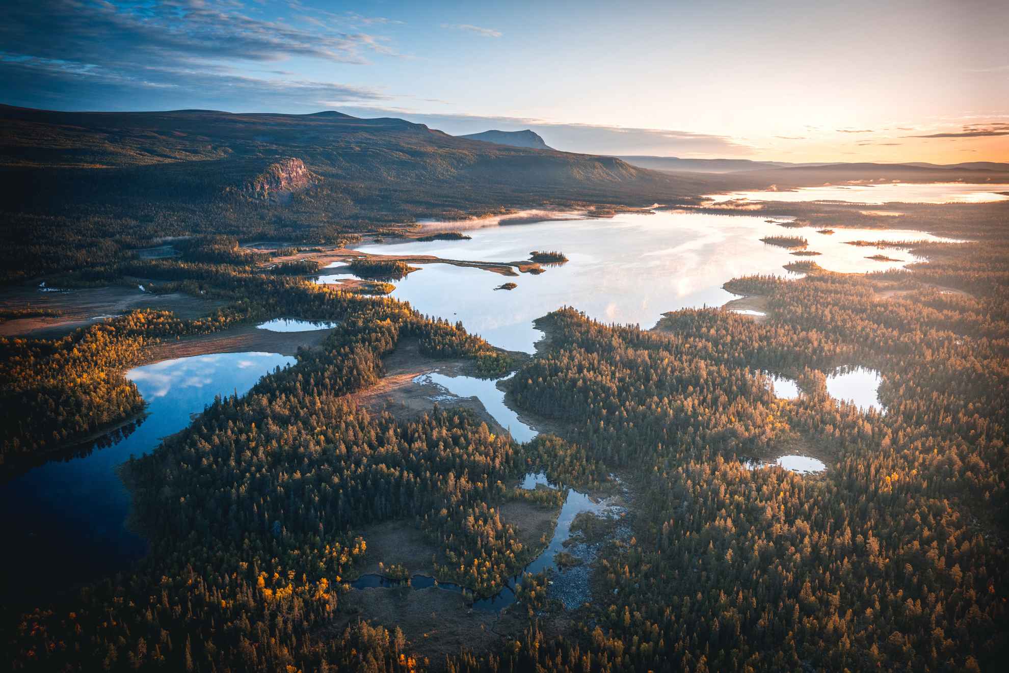 Een luchtfoto van een landschap met bossen en rivieren.