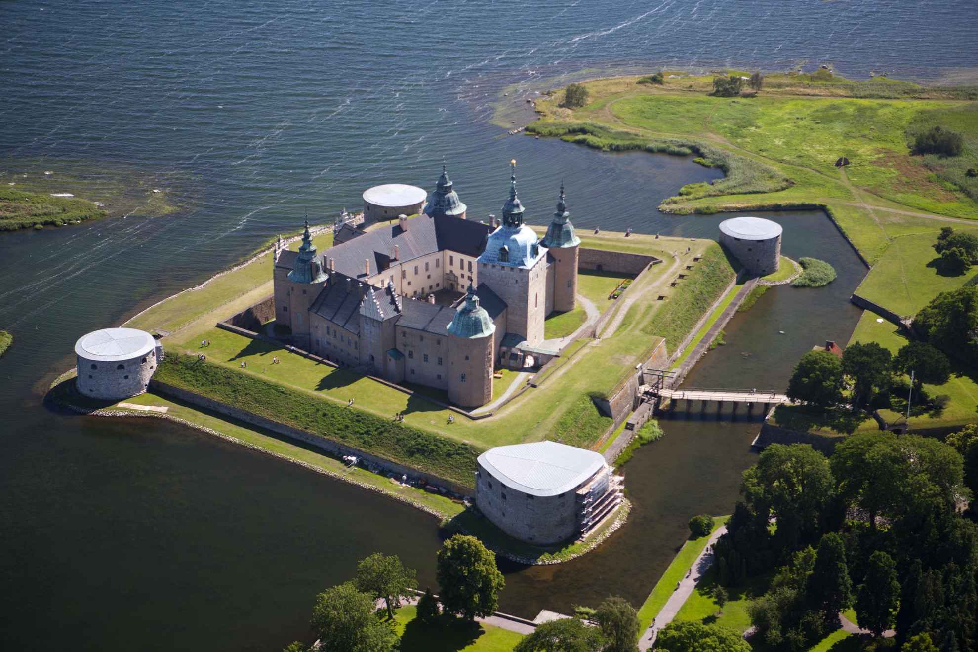 Luchtfoto van het kasteel van Kalmar, gelegen op een klein eiland omgeven door water met een kleine brug naar het vasteland.