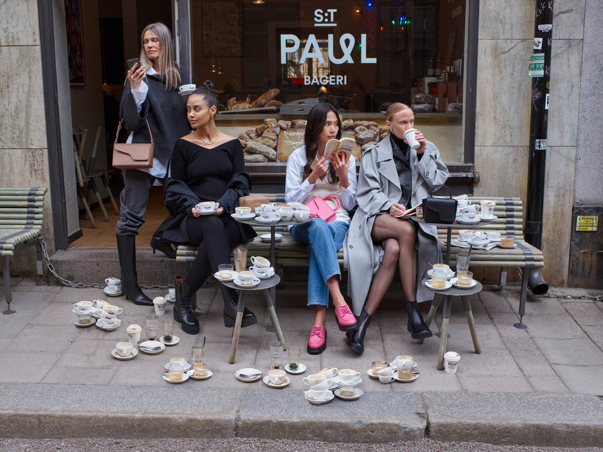 Modellen zitten buiten een café in Stockholm.