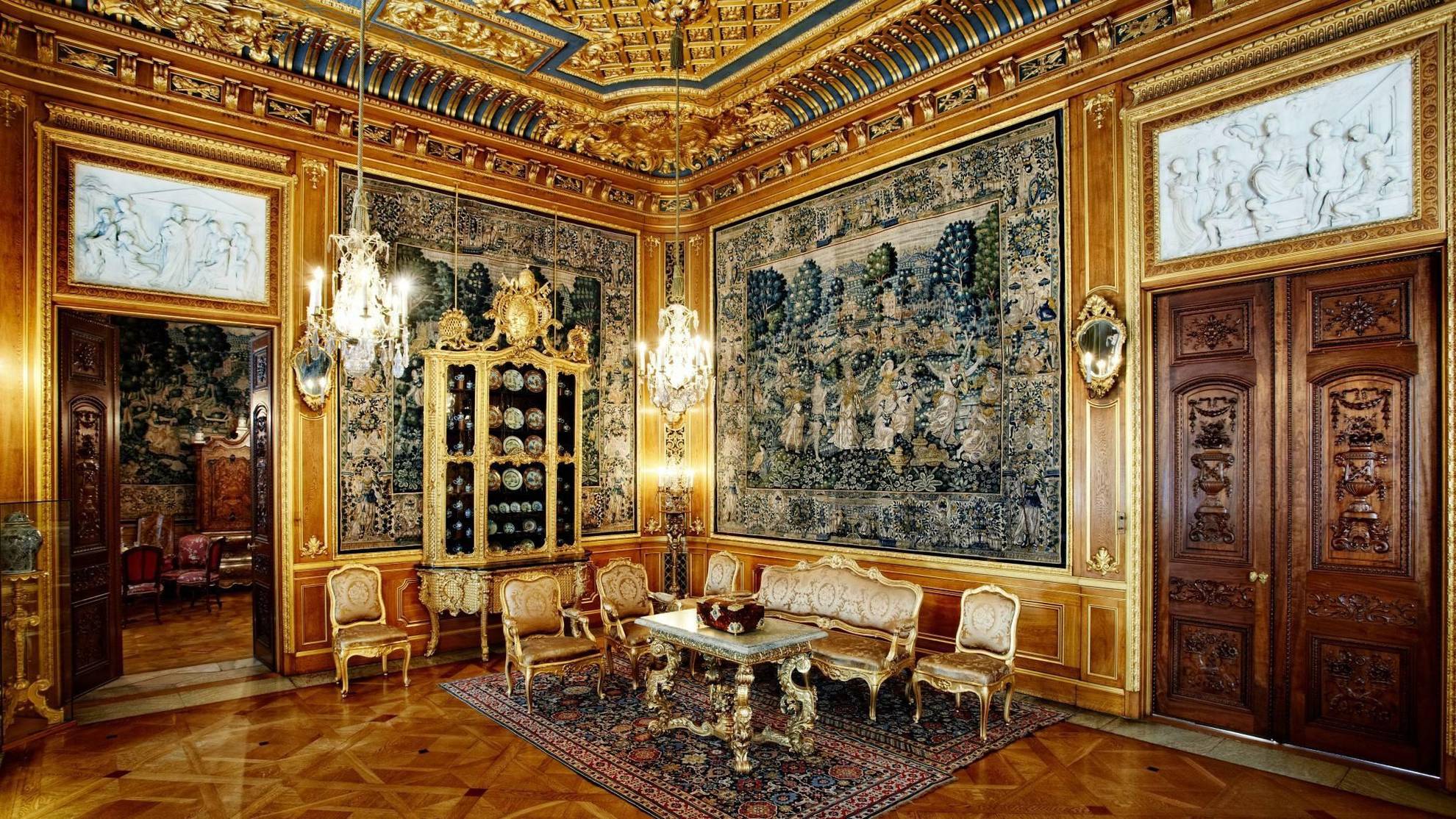 De luxe, gouden zitkamer van huis Hallwyl; met grote schilderijen, gouden meubels en kroonluchters.