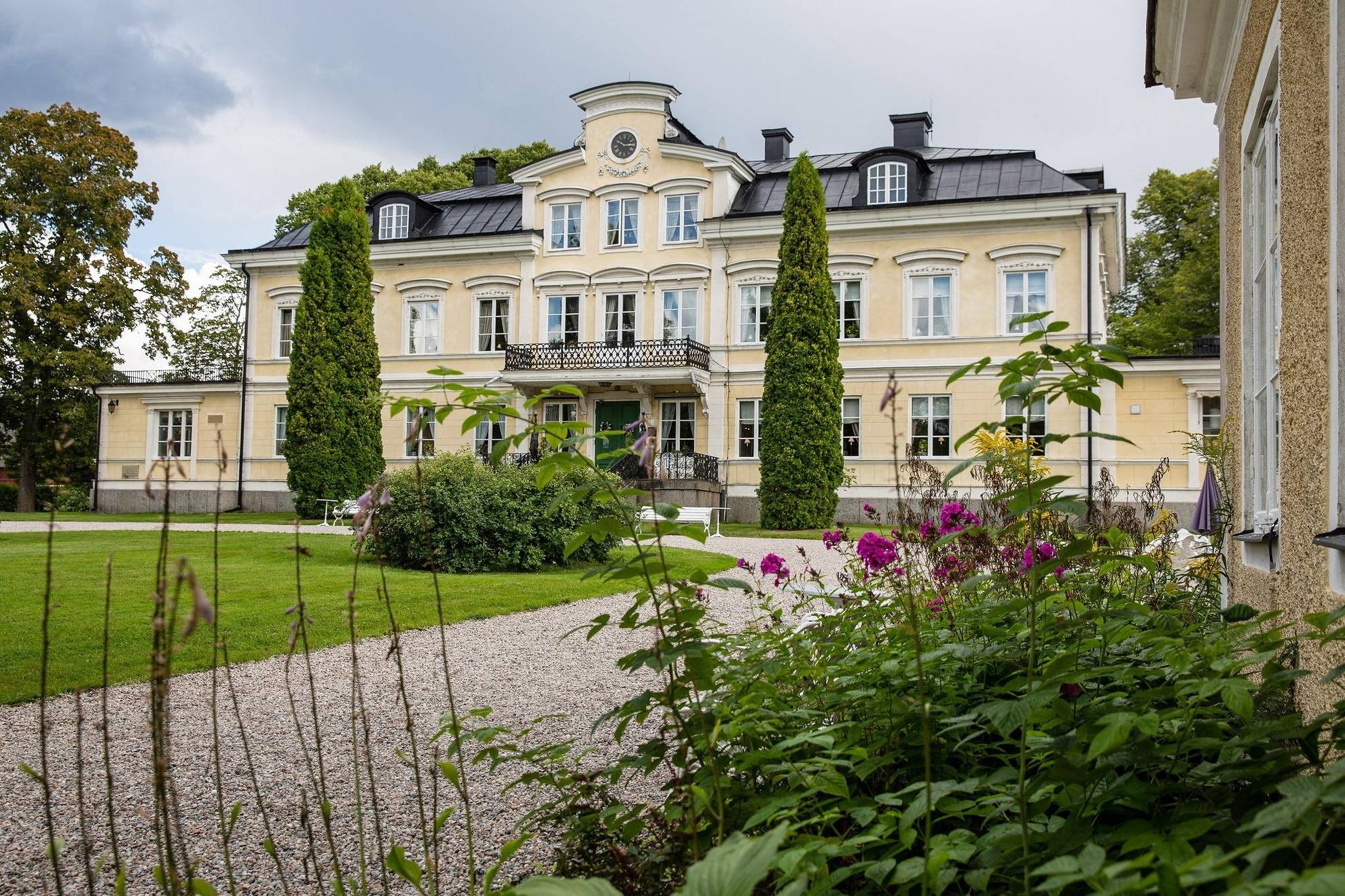 Het gebouw van landhuis Färna omgeven door groen tijdens een zomerse dag.