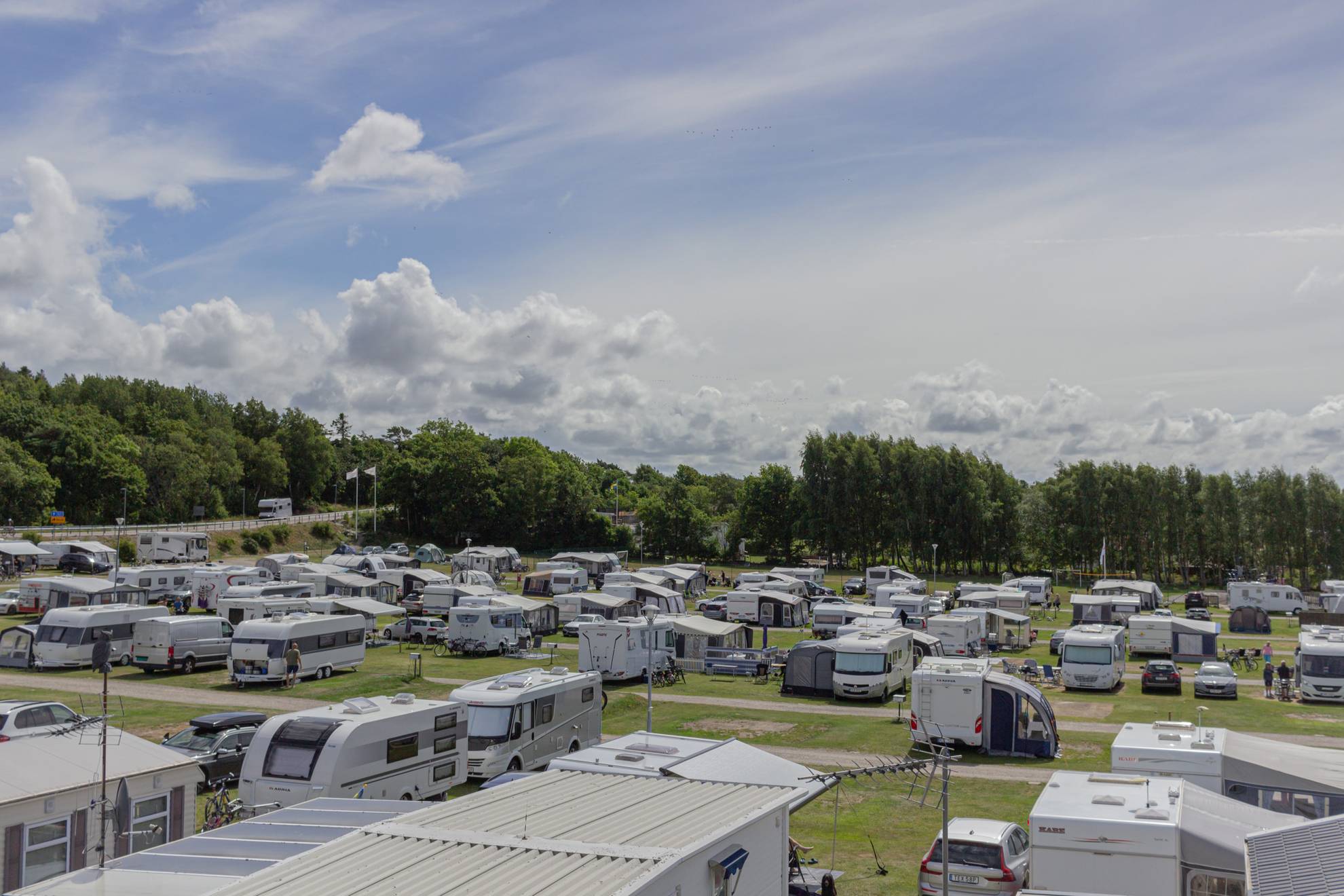 Caravans en campers geparkeerd op een groen kampeerterrein.
