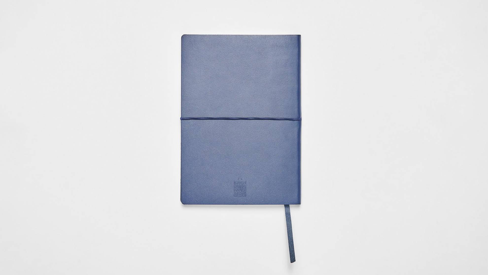 Een blauwe notitieblok op een wit oppervlak.