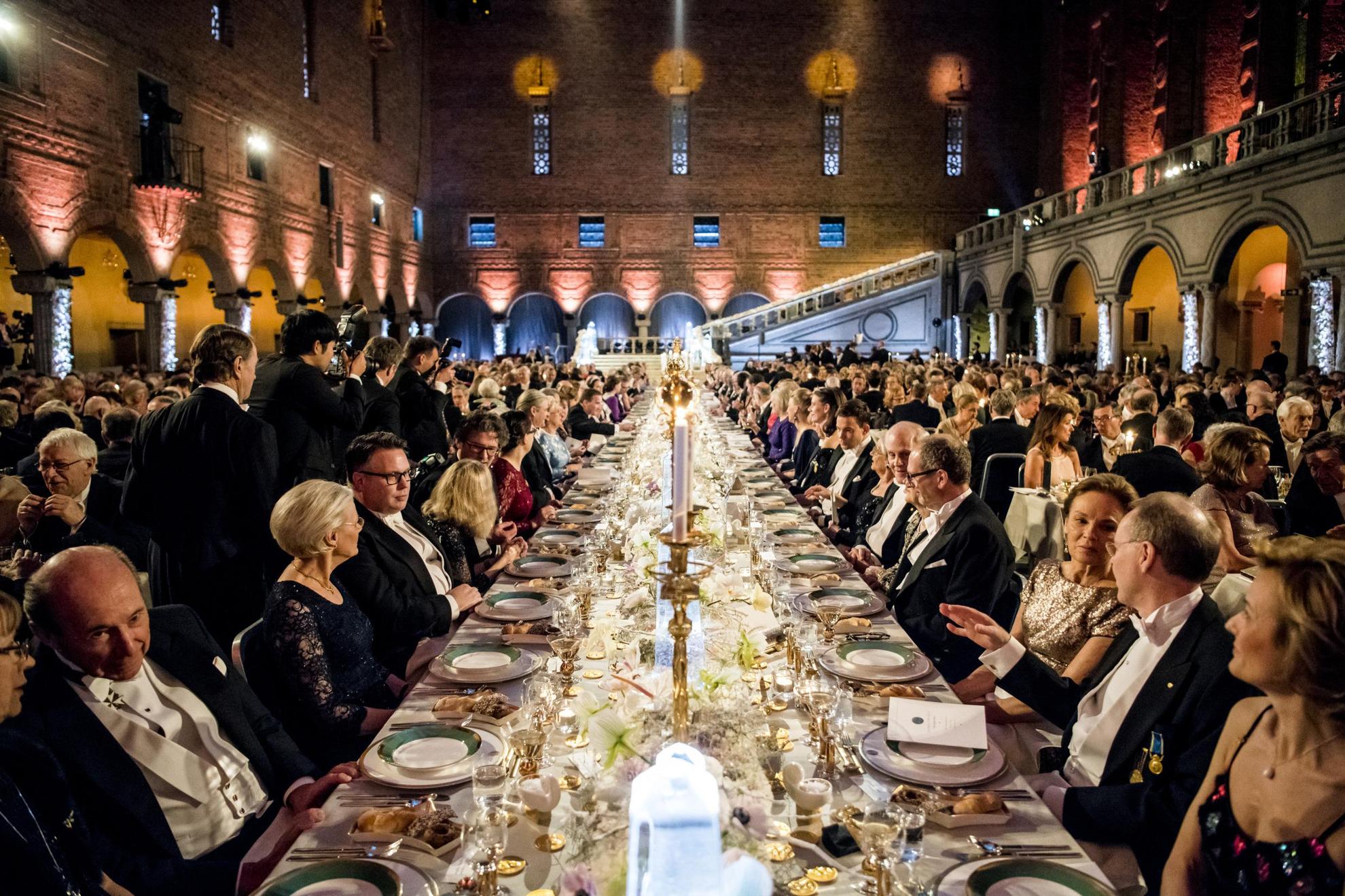 Gasten zitten aan een lange tafel tijdens het Nobel-banket.