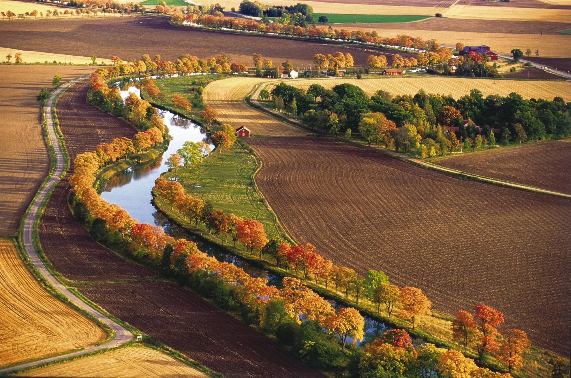 Luchtfoto van Gota Kanal en het omliggende landbouwlandschap met herfstkleuren.