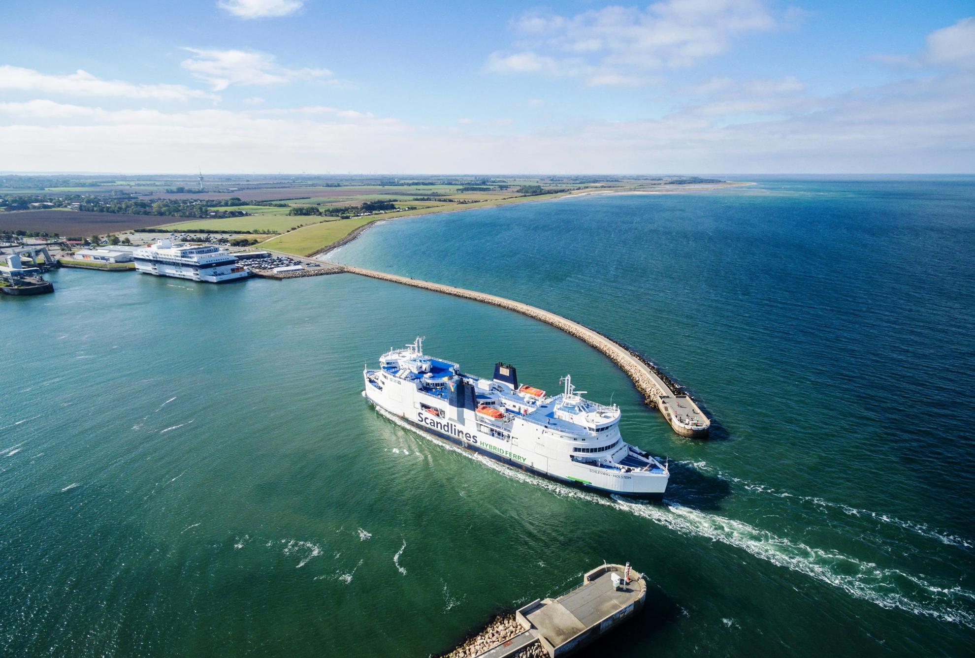 Een luchtfoto van een ferry die de haven binnenvaart.
