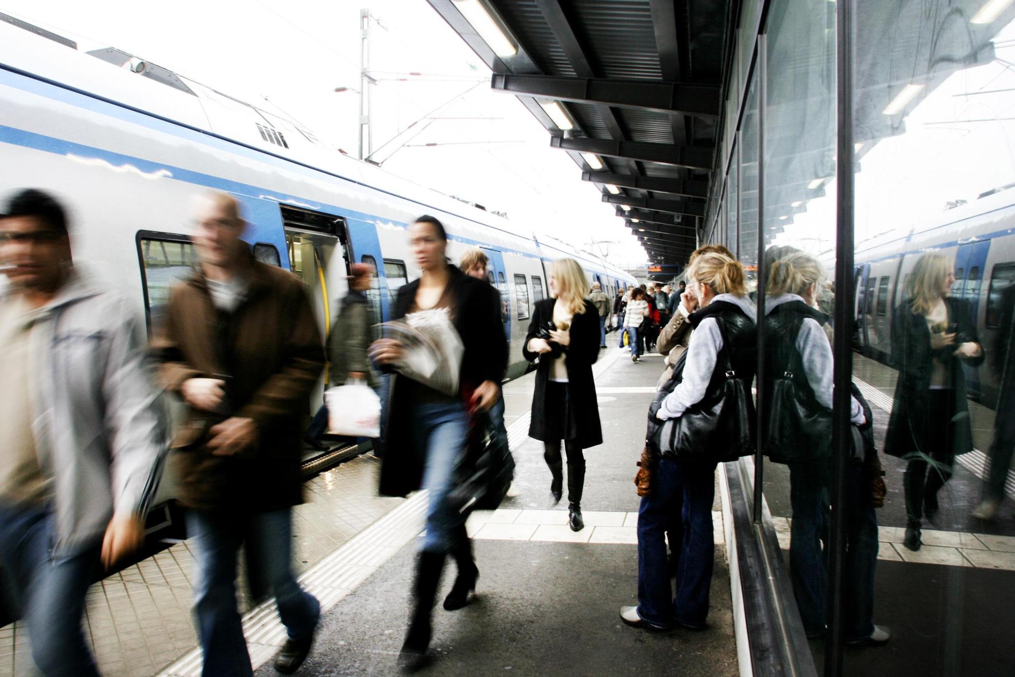 Mensen zijn aan het in- en uitstappen van een metrostel op een druk bovengronds metrostation.