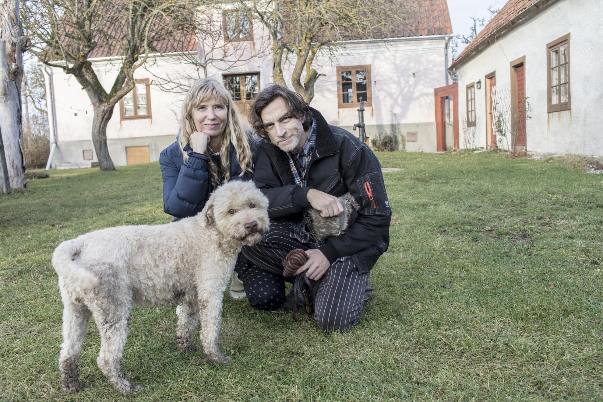 Voor een wit landhuis staan de kunstenaars Karin Mamma Andersson en Jockum Nordström en een hond.