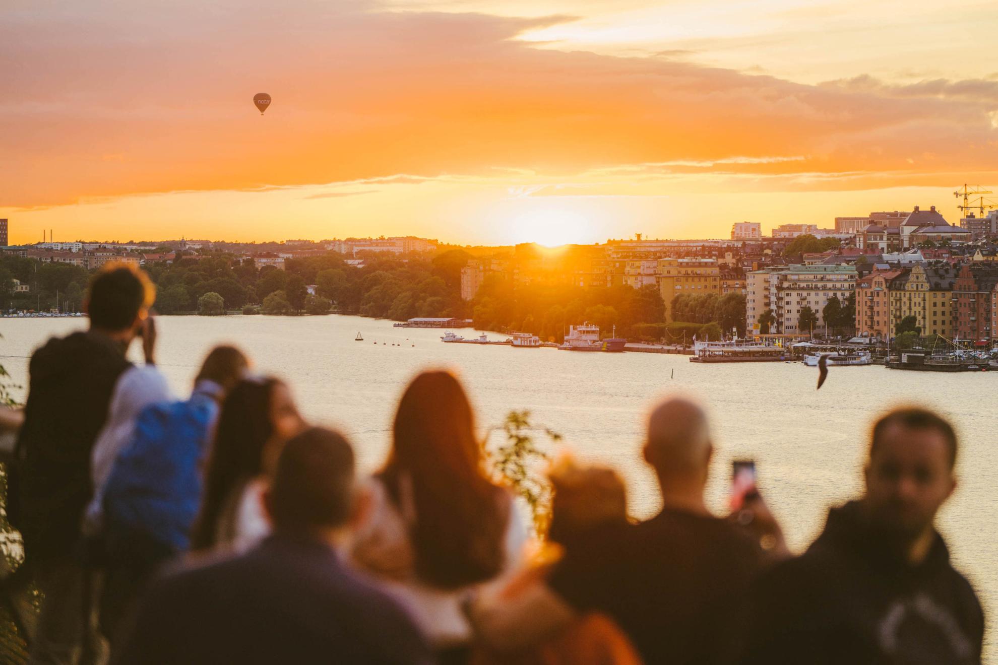 Een groep mensen kijken naar de zonsondergang in Stockholm.