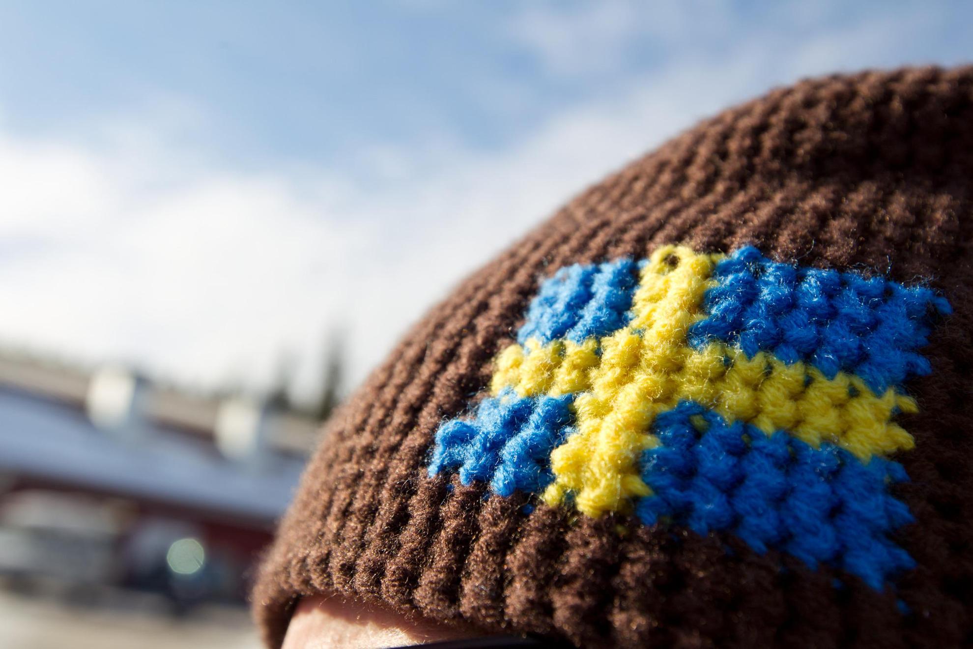 Een gehaakte wollen wintermuts met Zweedse vlag op.