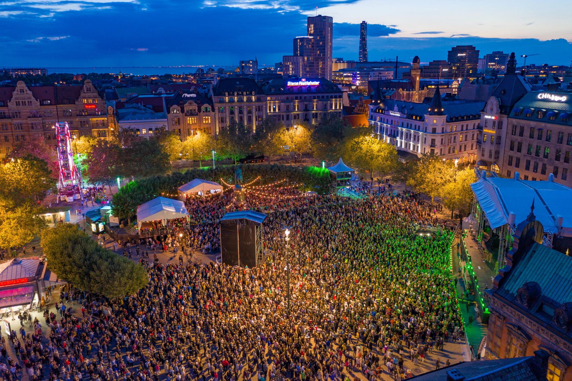 Een dronebeeld over het Malmö Festival in de avond, met duizenden bezoekers voor een groot podium.