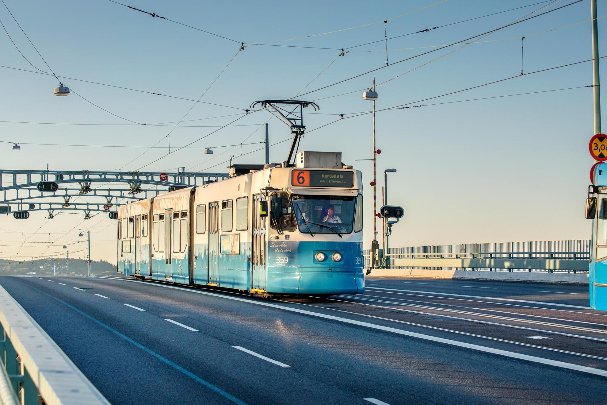 Een blauwe tram rijdt over een brug.