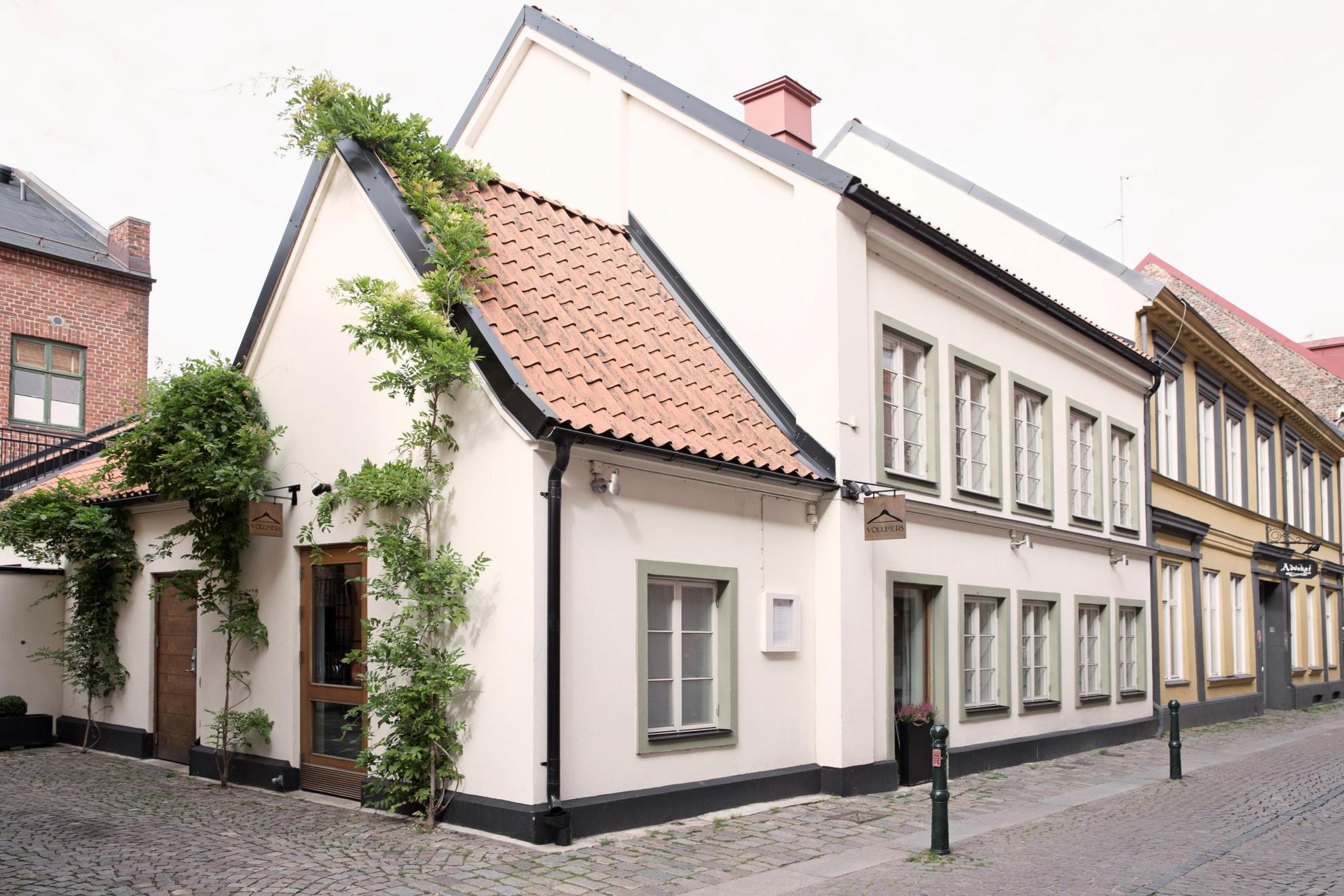 De buitenkant van restaurant Vollmers in Malmö, een wit huis met klimplanten bij de ingang.